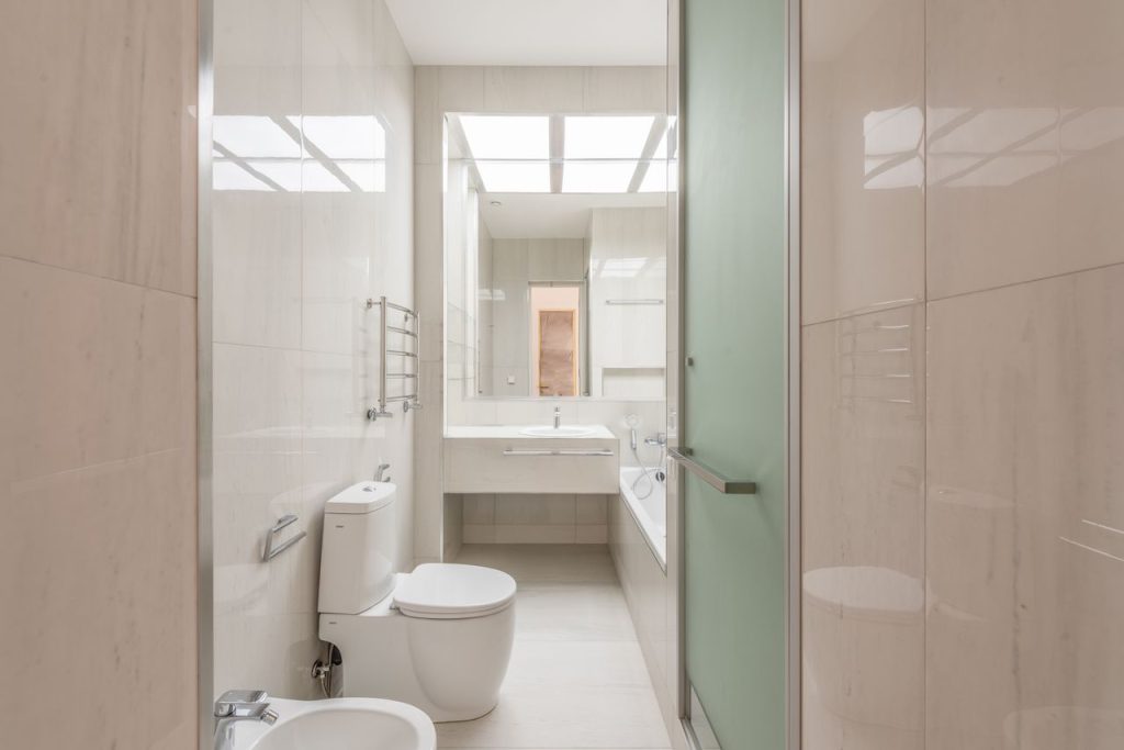 A spacious, contemporary bathroom featuring a skylight, pristine fixtures, and modern design elements.